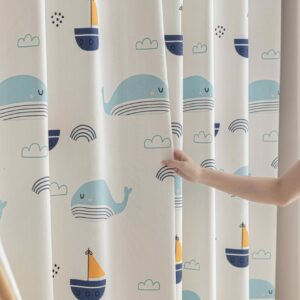 Detail van kinderkamer gordijnen met walvis en zeilboot print in zachte blauw- en geeltinten