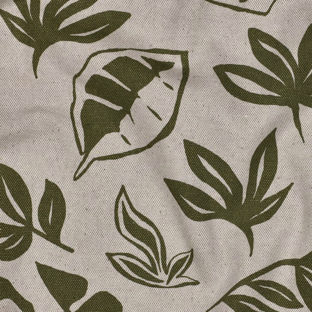 Close-up van naturel linnenlook gordijnen met groene bladprint en zachte plooien