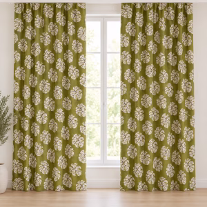 Groene gordijnen met crèmekleurige tropische bladeren, hangend voor een raam.