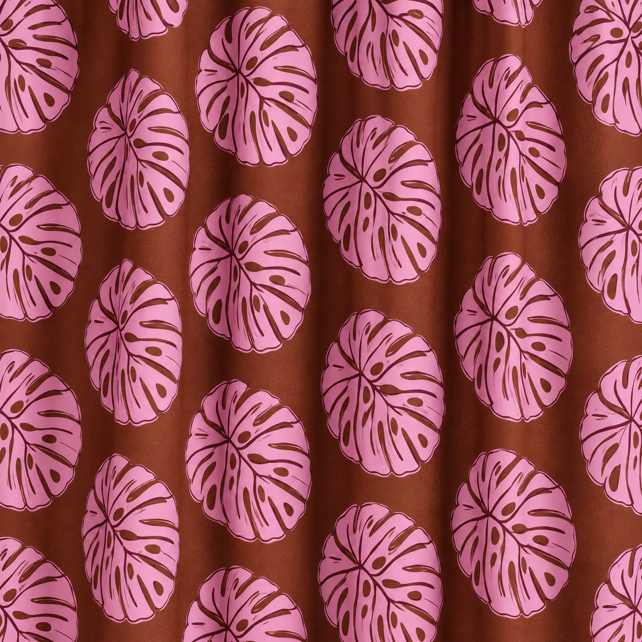 Close-up van bruine katoenen gordijnen met roze bladprint en zachte plooien.